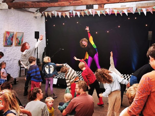 Woman in leotard leads children in an exercise class