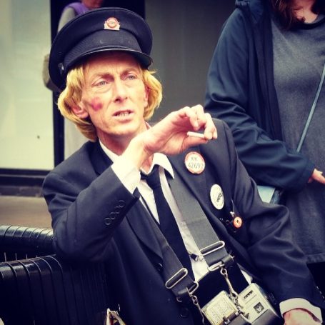 Old fashioned male bus conductor relaxes with a cigarette