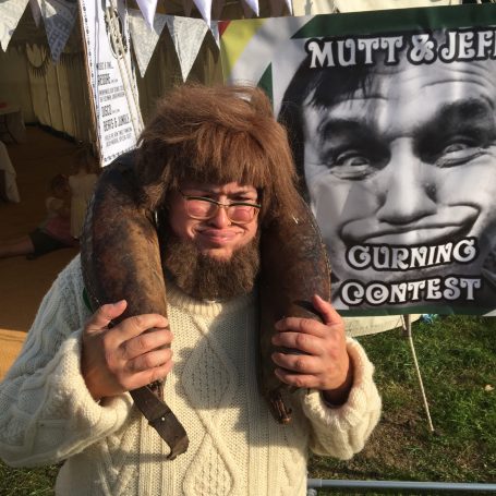 Man in braffin collar pulls an extraordinary face in a traditional  gurning contest